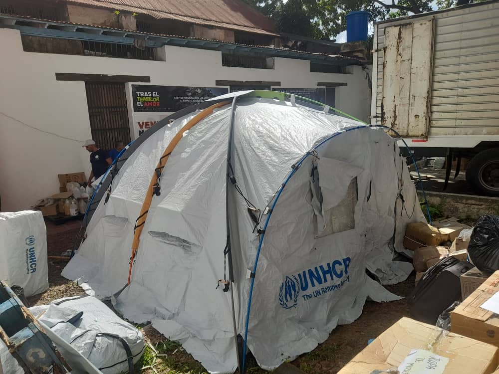 Zelt von UNHCR steht zwischen zerstörten Häusern
