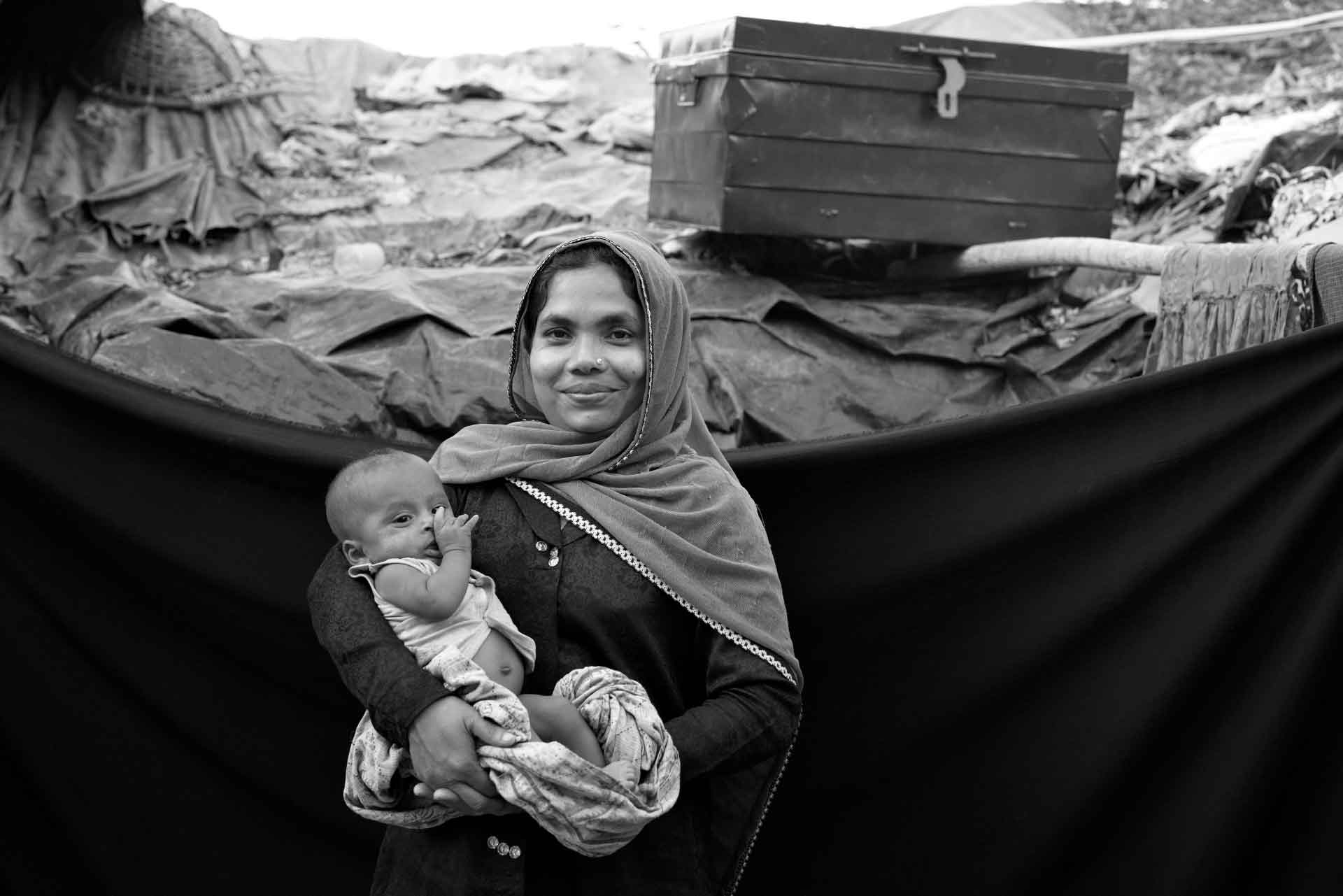 Rohingya Flüchtling Noura hält ein Baby im Arm