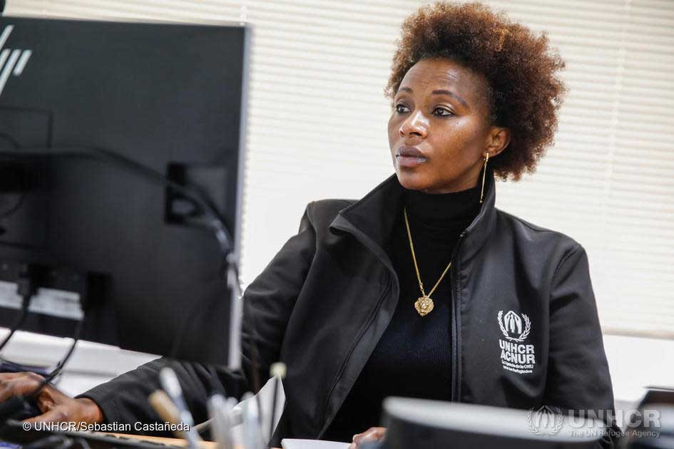 UNHCR-Mitarbeiterin Juliette arbeitet am Schribtisch