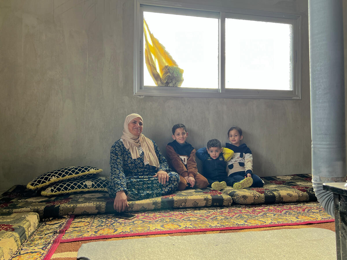 Nihad sitzt mit ihren Enkelkindern Ali (10), Sham (8) und Mysarah auf einer Matratze in ihrem Haus im Dorf Kahil in der Provinz Dar'a.