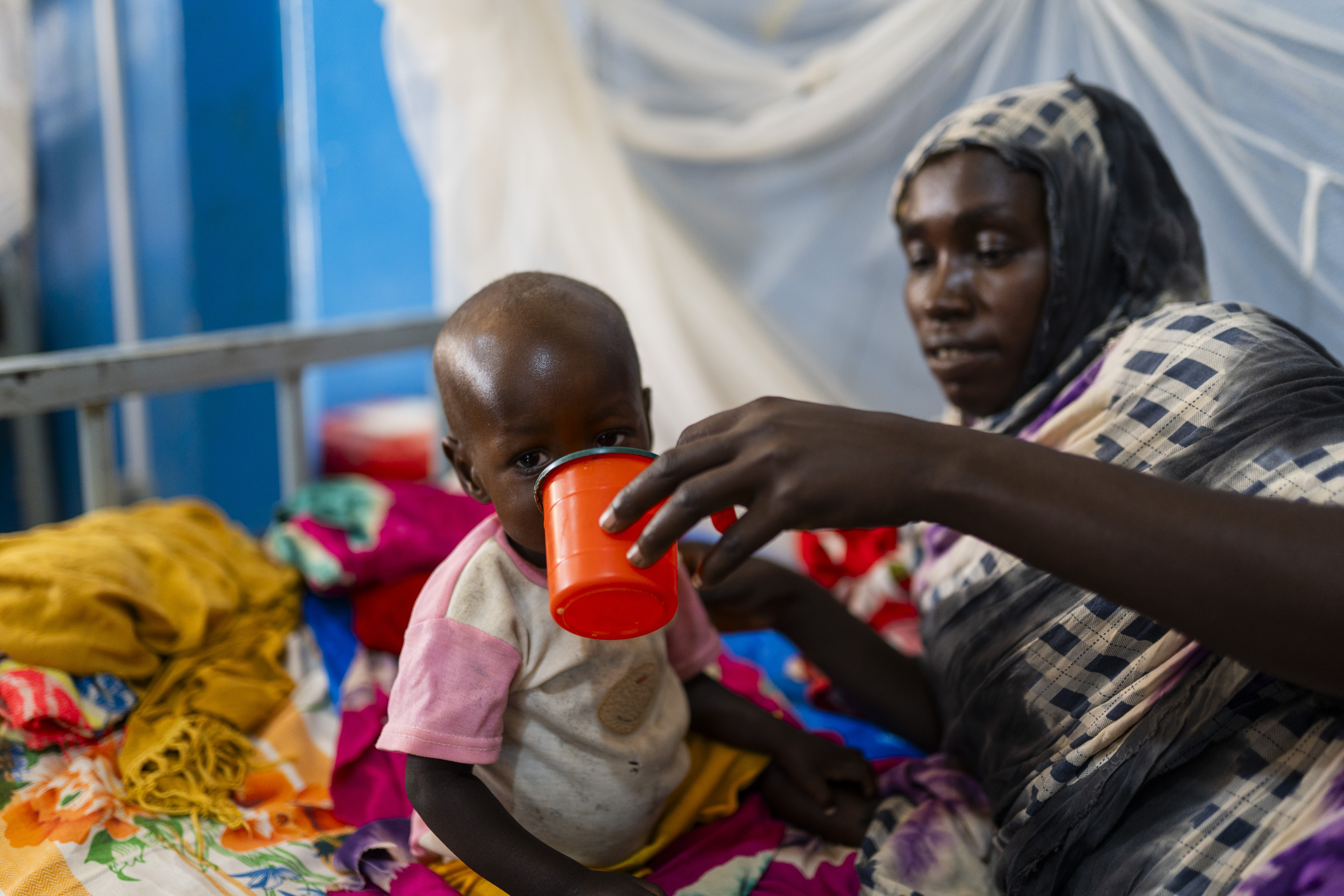 Eine Mutter füttert ihr mangelernährtes Kind