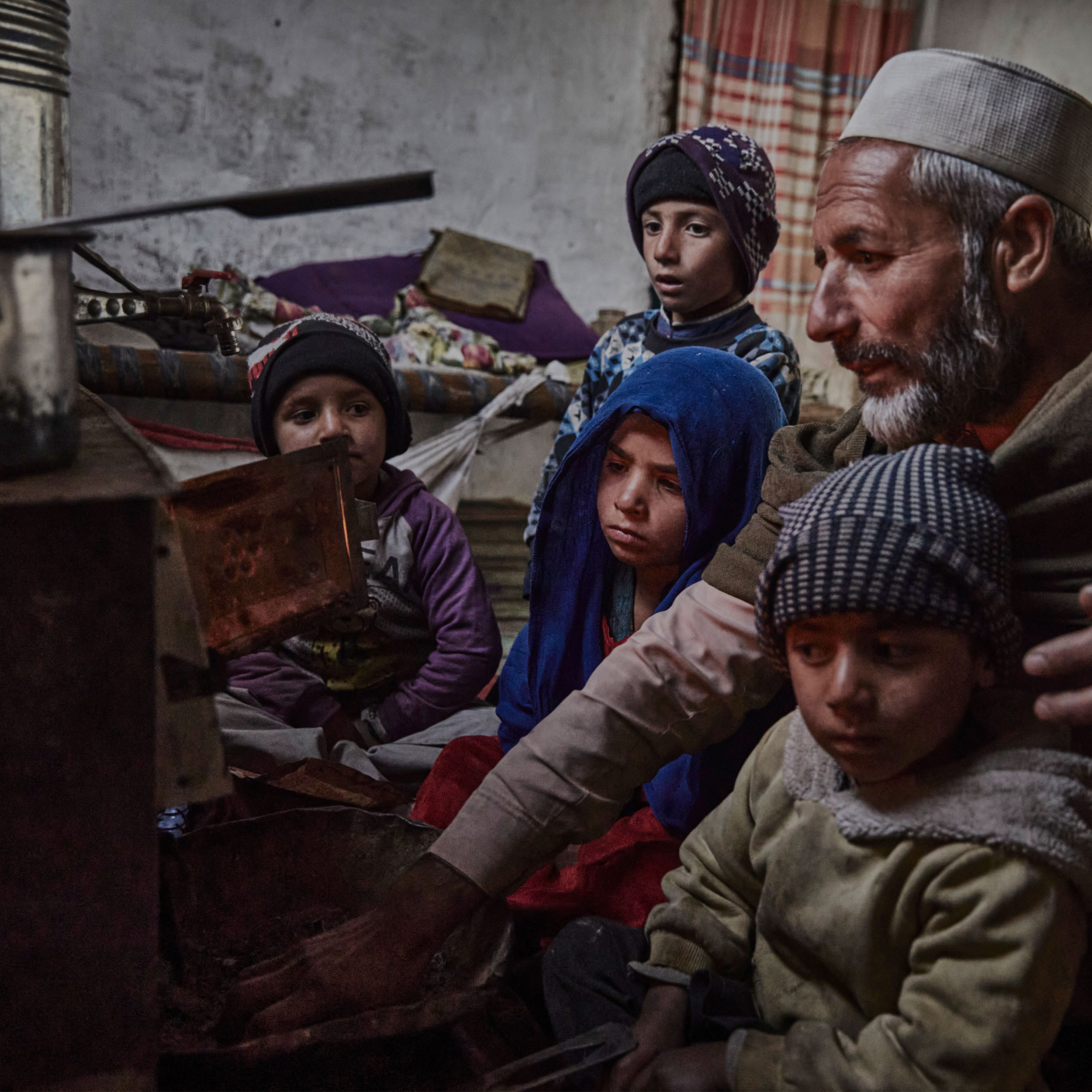 Flüchtlingsfamilie in Afghanistan vor dem Ofen