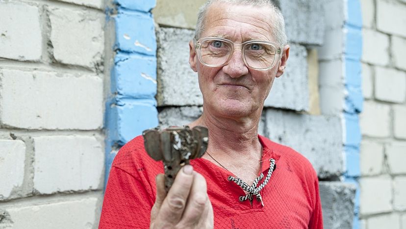 In der Hand hält der 55-jährige Semen die Überreste einer Mine, die in seinem Garten in einem kleinen Dorf in der Ukraine lag. Als sie explodierte, wurde er von den umherfliegenden Teilen verletzt. Er kann von Glück sagen, dass er überlebt hat.